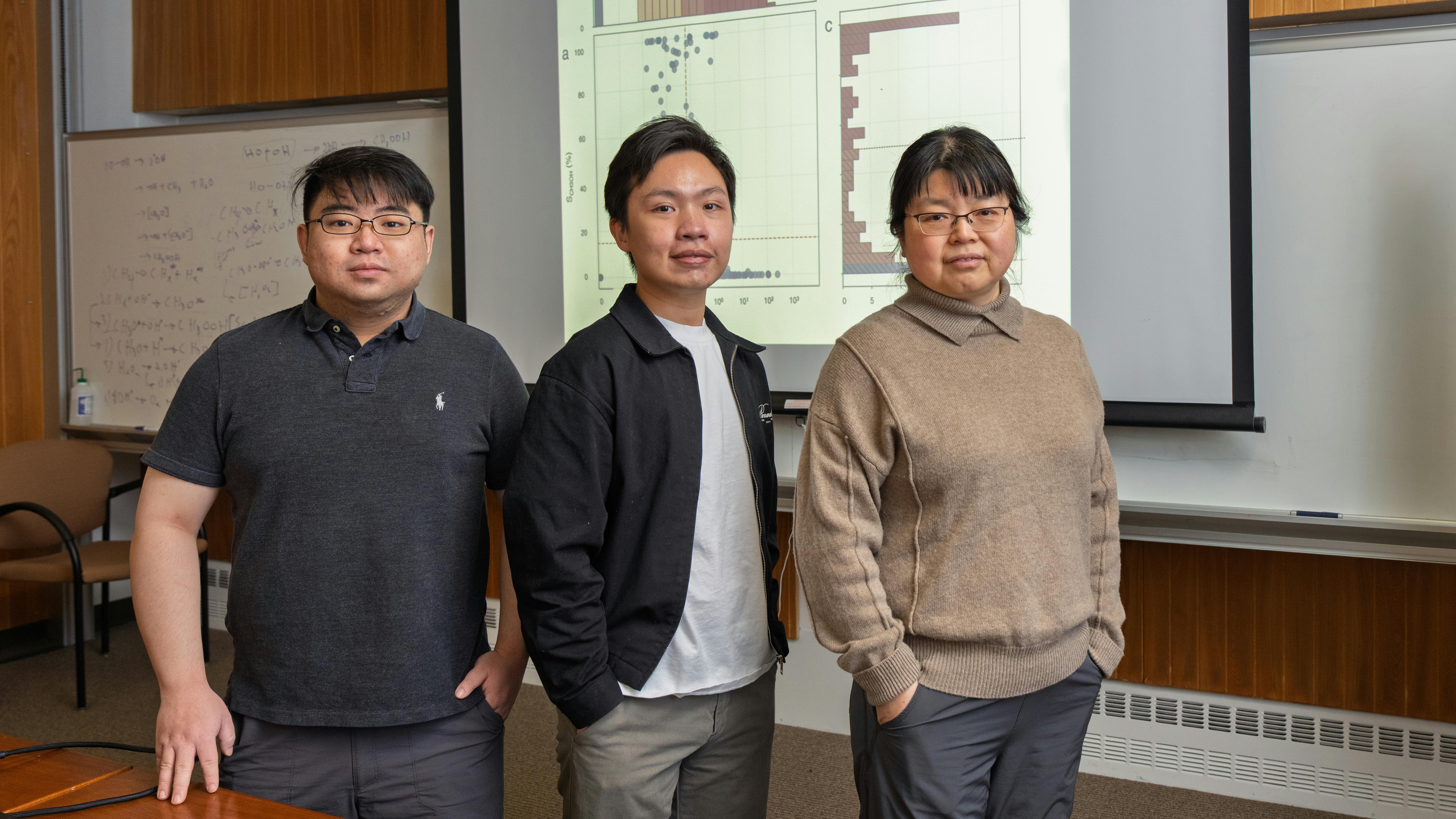 Researchers at Brookhaven Lab developed a machine learning framework to search for ideal catalysts. From left to right: Wenjie Liao, An Nguyen, and Ping Liu, share data from a case study that tested the framework in a new paper in Chem Catalysis. (Timothy Kuhn/Brookhaven National Laboratory)
