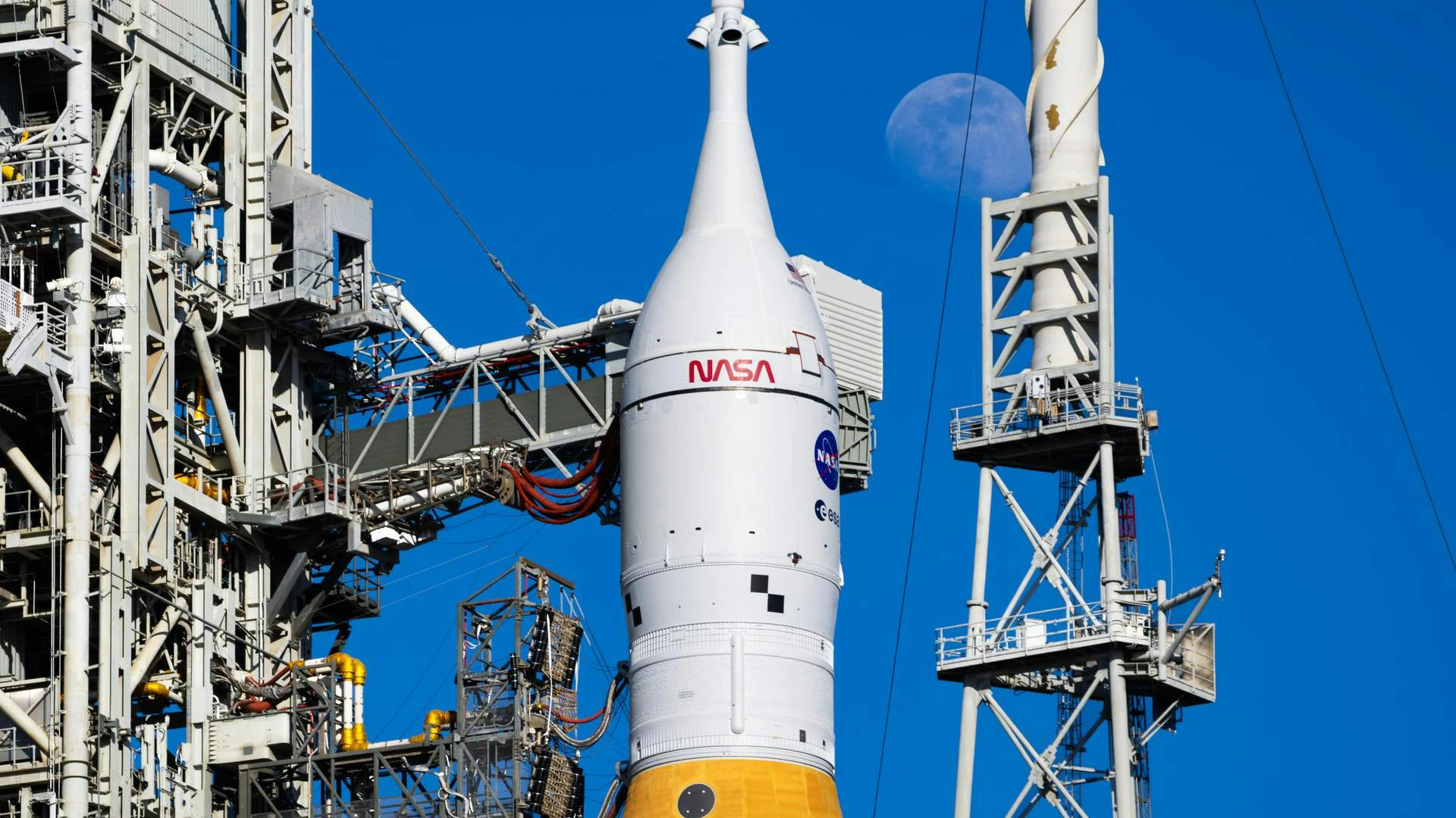 The Moon is seen shining over the SLS (Space Launch System) and Orion spacecraft, atop the mobile launcher on January 28, 2026. The rocket is currently at Launch Pad 39B at NASA&rsquo;s Kennedy Space Center in Florida, as teams are preparing for a wet dress rehearsal to practice timelines and procedures for the launch of Artemis II.