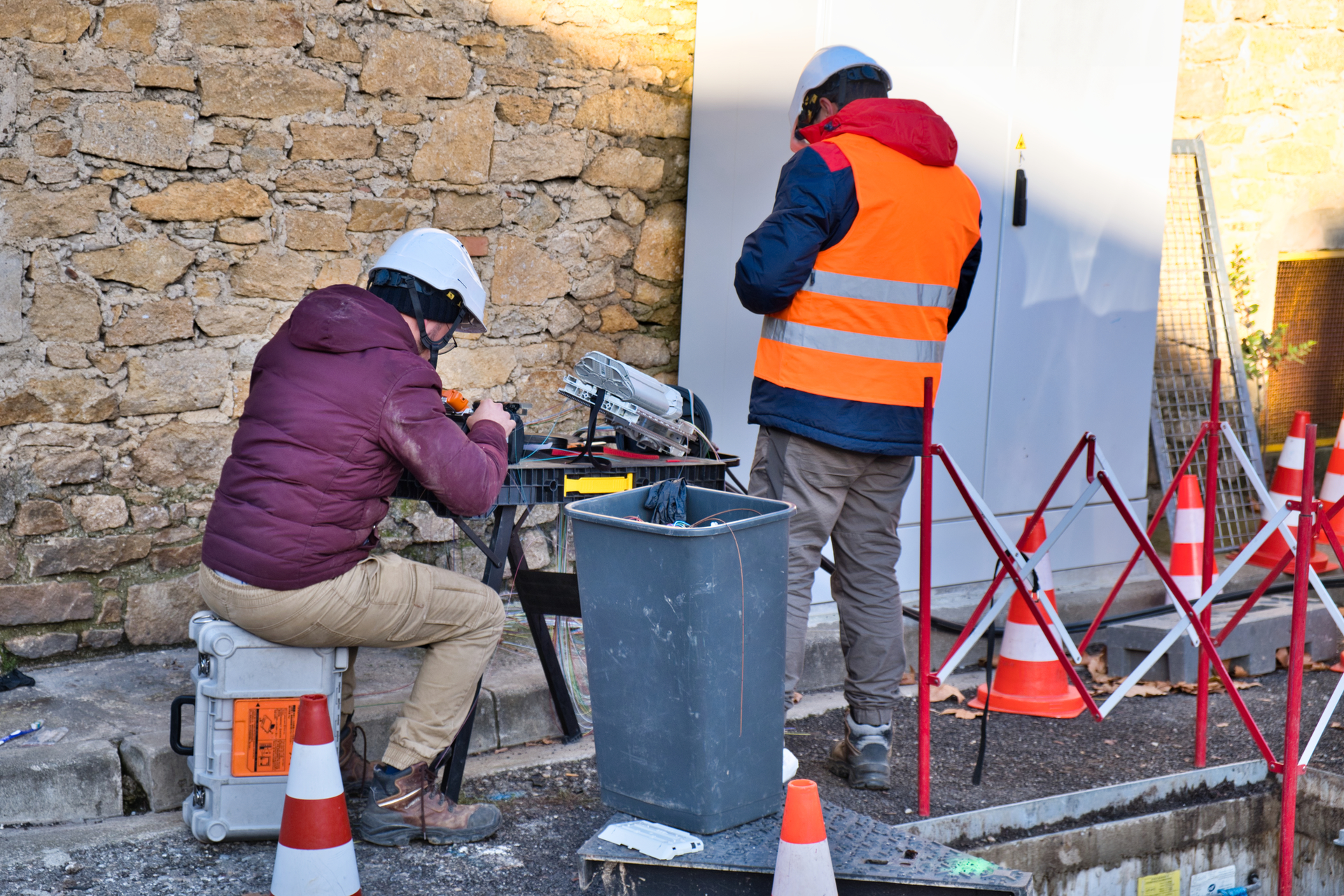 Technicians working on a street installing fiber-optics for a high speed internet network.