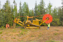 Workers laying fiber-optic cable. Workers laying fiber-optic cable.