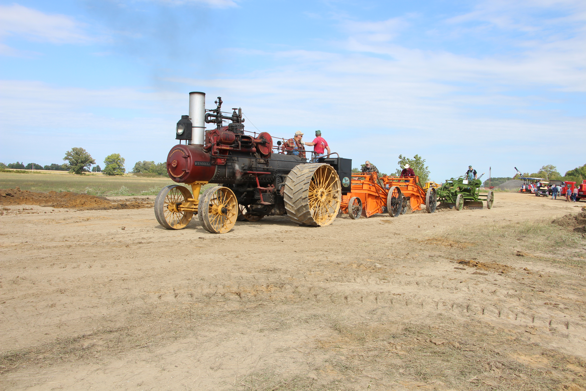 A 1918 Russell & Co. 30/90 traction engine pulls two 1920s Baker Maney D wheeled scrapers and a 1929 Galion Leaning Wheel E-Z Lift No. 10 pull grader.