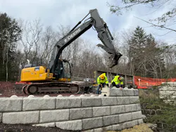 Rutledge workers place stone on a retaining wall and small bridge project. Rutledge workers place stone on a retaining wall and small bridge project.