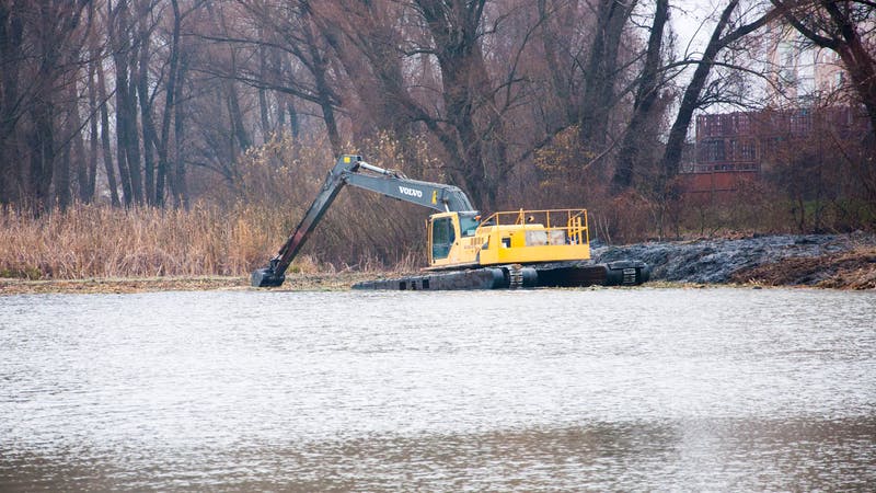 An amphibious excavator similar to this one tipped over into the water.