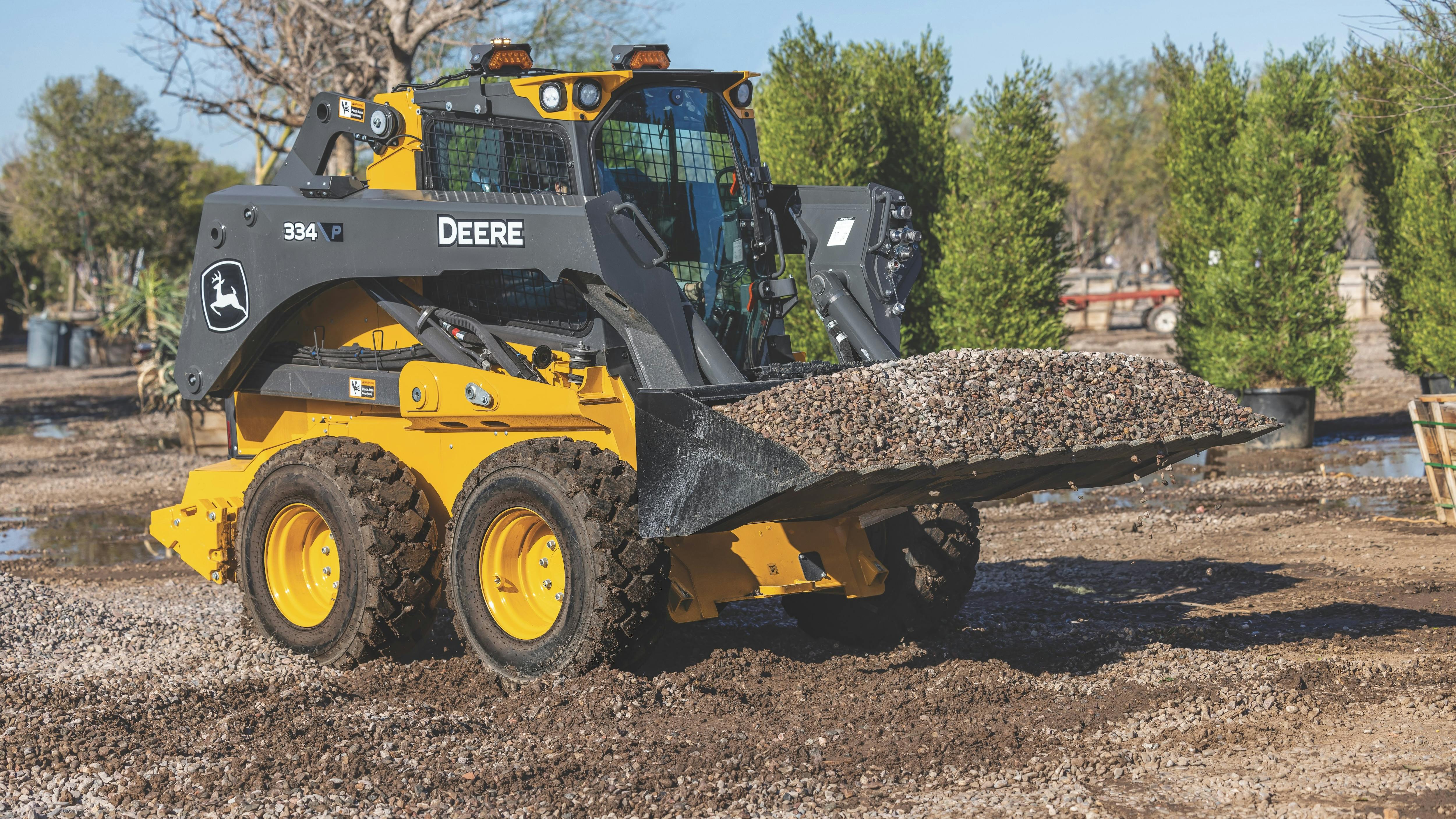 When loading a skid steer or compact track loader onto a trailer, keep the boom and attachment low.