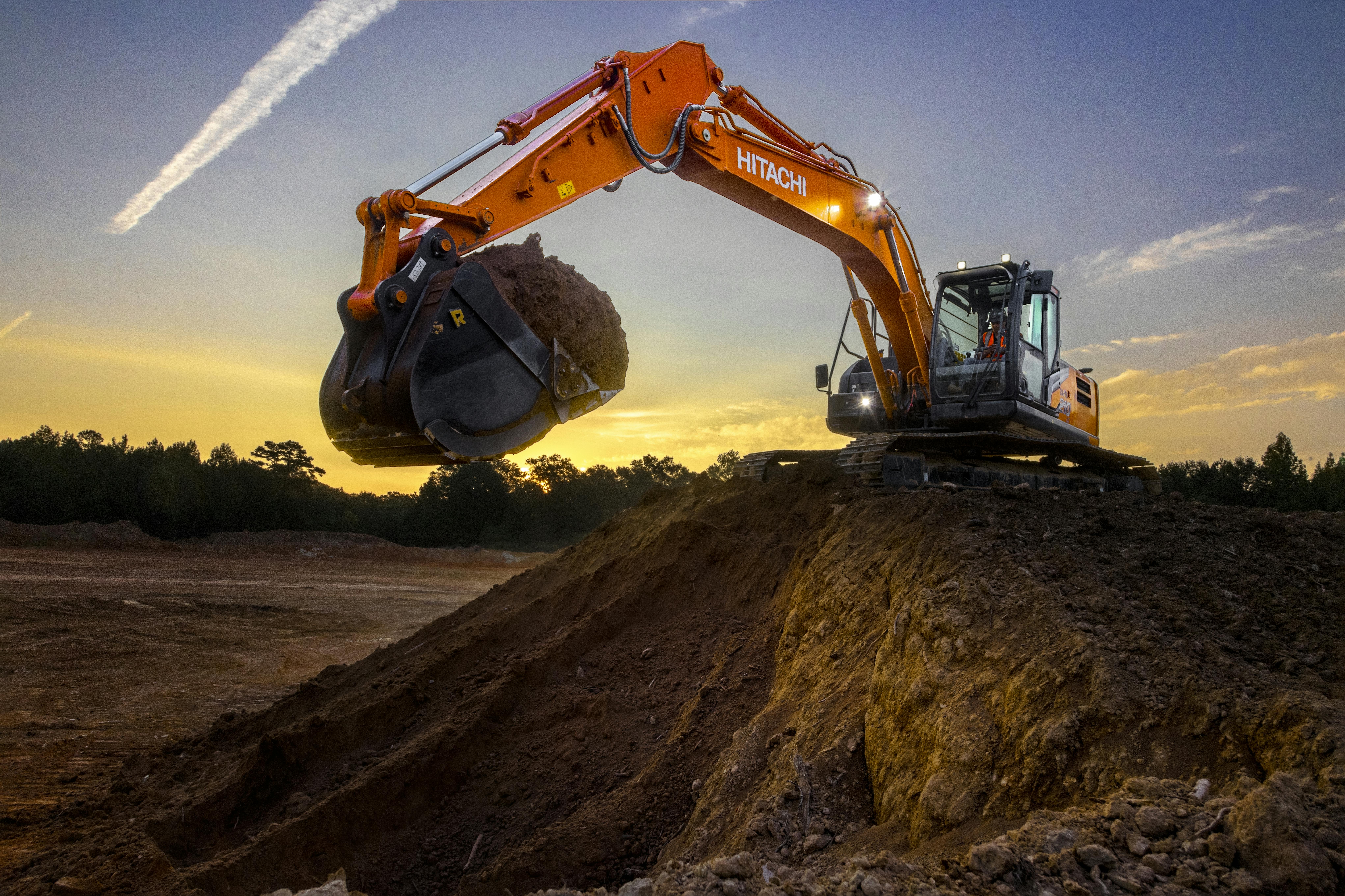 Hitachi Construction Machinery ZX210LC-7H lifting a bucket of dirt