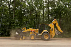 Caterpillar 450 backhoe loader using a broom attachment Caterpillar 450 backhoe loader using a broom attachment