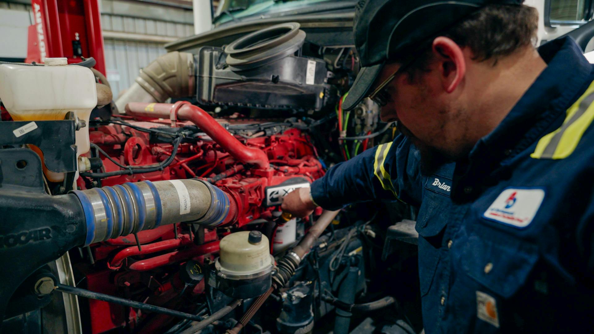 Fleetio mechanic checking a red engine