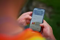 Ditch Witch’s Orange Intel telematics system on a phone. Ditch Witch’s Orange Intel telematics system on a phone.