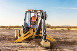 John Deere backhoe loader digging in the dirt on the backhoe side. John Deere backhoe loader digging in the dirt on the backhoe side.