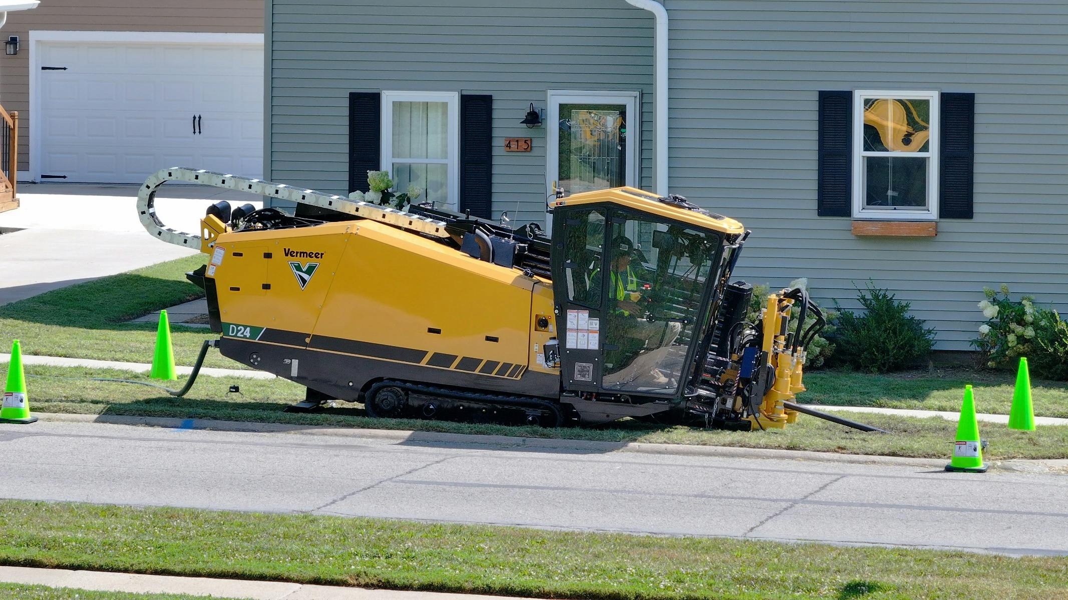 Vermeer D24 horizontal directional drill with cab drilling by house.