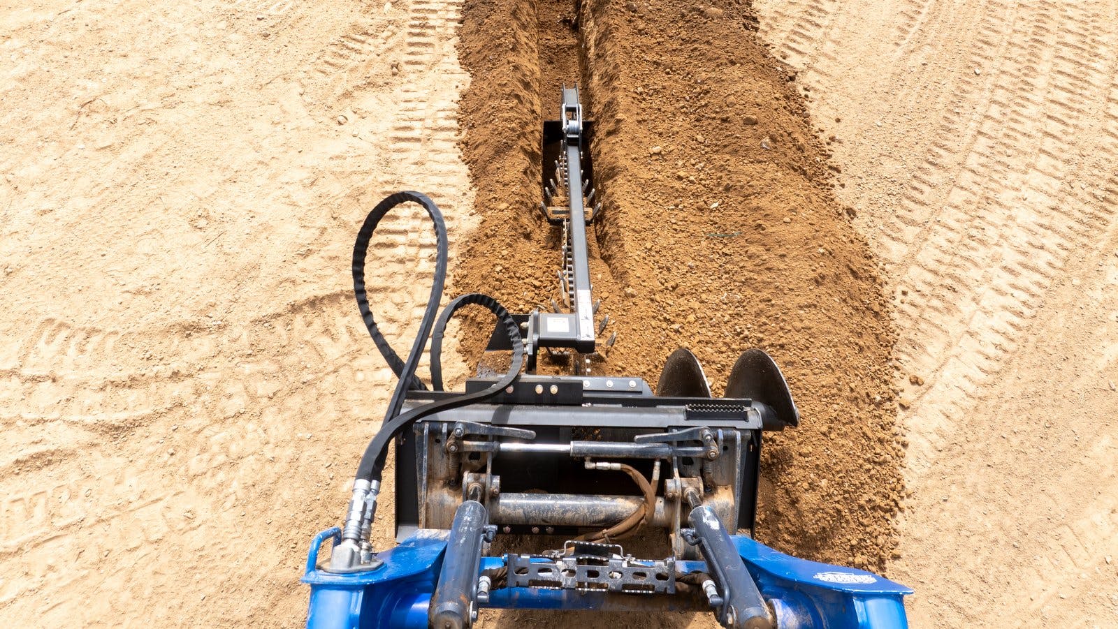 Blue Diamond Trencher Attachment cutting through dirt