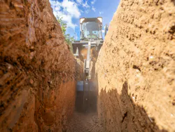 Blue Diamond trencher attachment cutting through the ground Blue Diamond trencher attachment cutting through the ground