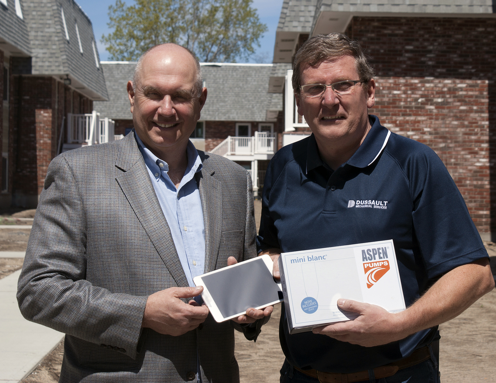Michael Clarke right president of HVAC contractor Dussault Mechanical Services Hudson NH receives his Golden Ticket award mdashan iPad Mini3 mdash from Robert Forbes partner Gimper Forbes LLC Edison NJ RectorSealrsquos New England territory manufacturerrsquos representative Clarke foundthe Golden Ticket in a Mini White Series Aspen Pump package he purchased from HVACR distributor Homans Associates Wilmington Mass