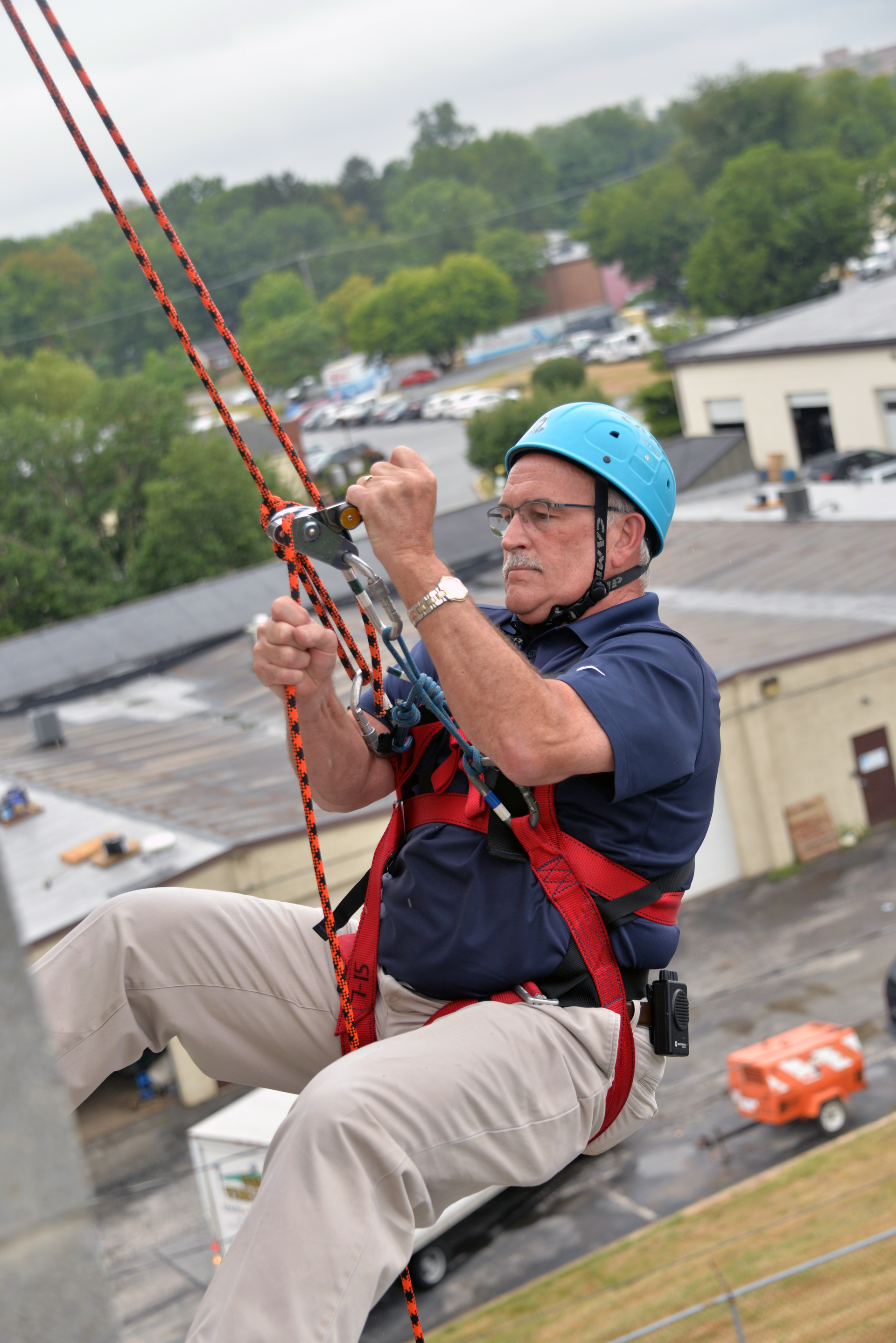 Yeah, right! Bill Ronanye the rappeller descends one floor at a time for a community cause.