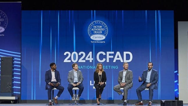 Braden Cook, right, Director, Product Management & Training, Residential HVAC, speaks with panelists during the Carrier national meeting.