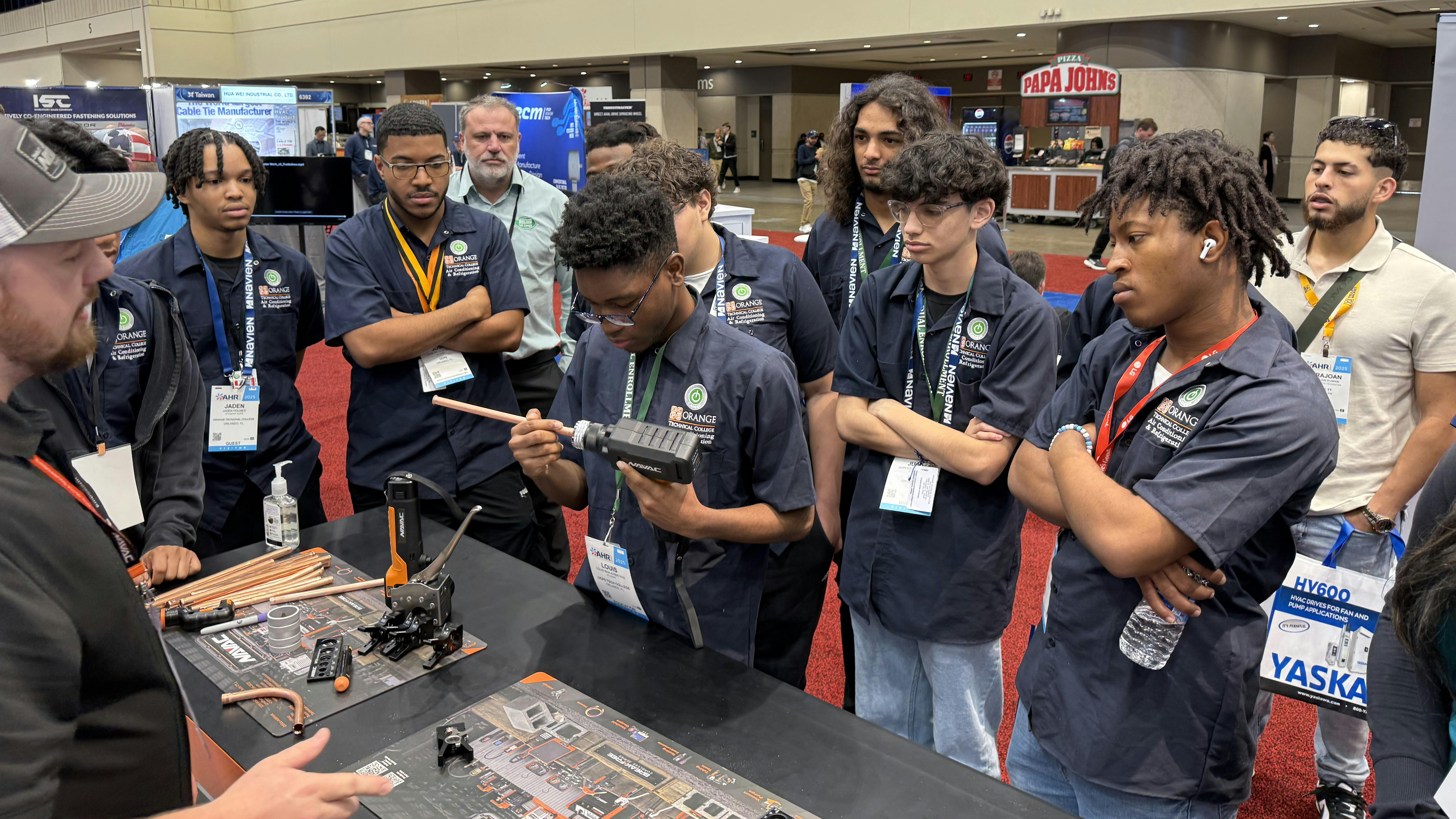 Students learning about new tools at the NAVAC booth.