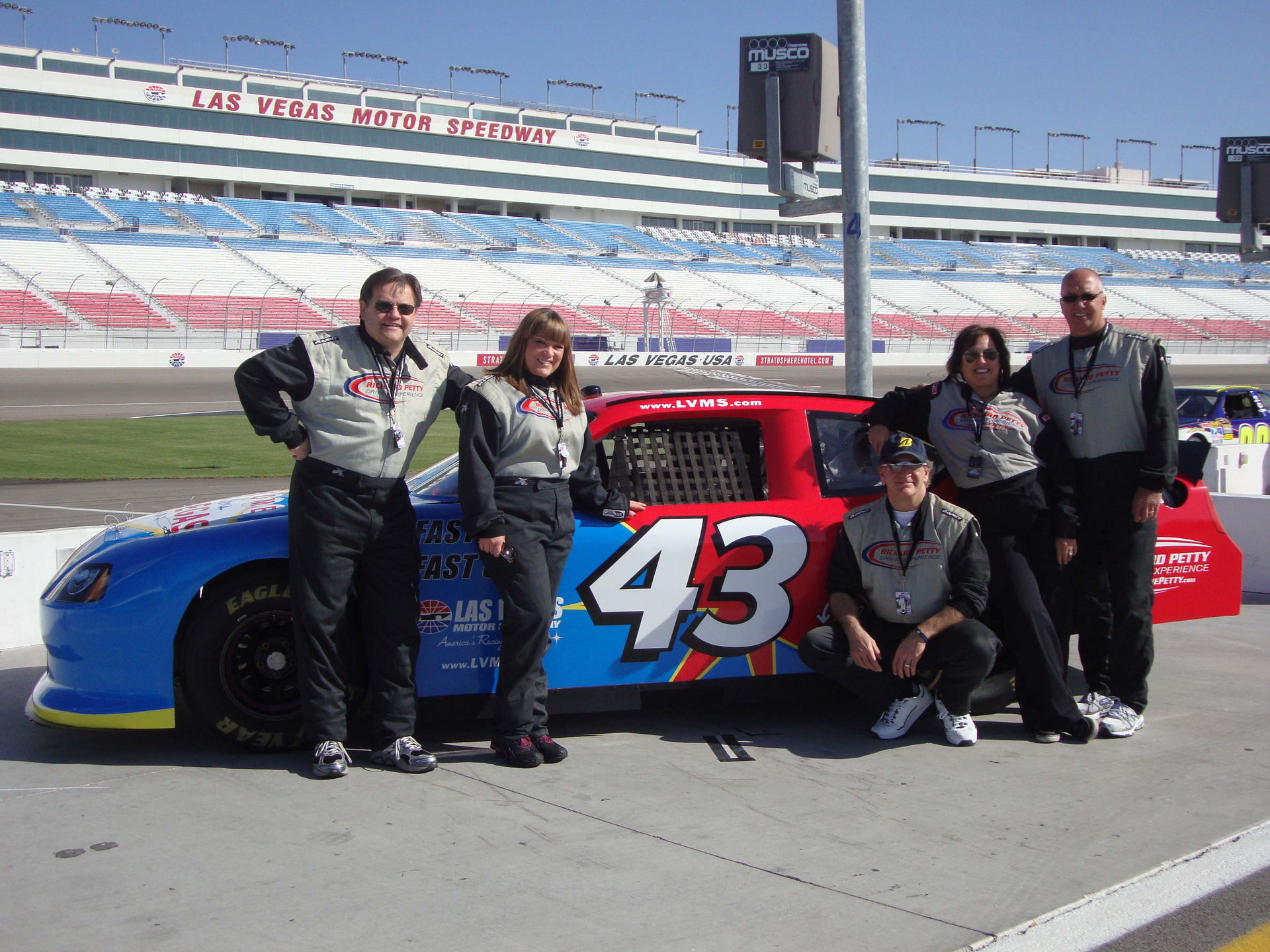 Rich Diesel right and his wife Marci next to him share a proud moment at Richard Petty Driving Experience in Las Vegas NV with Taco Trainer John Barba next to Marci Kim Ziner from EmersonSwan and Tacos VP of Eastern Regional Sales Ken Andersen Rich Diesel won Tacos Just Your Speed promotion