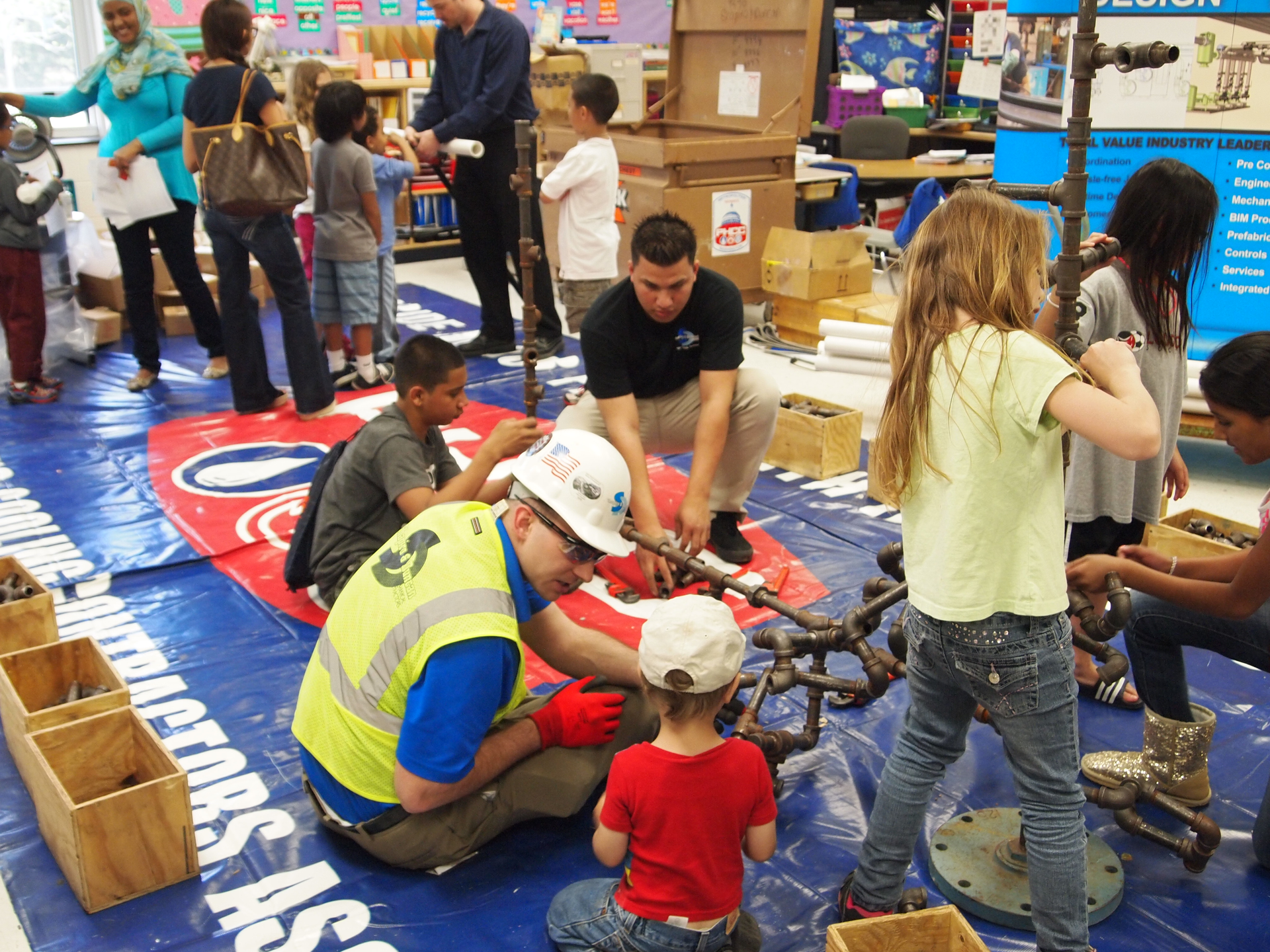 Thomas J Berlin a project engineer with Shapiro amp Duncan guides Pinebrook Elementary School students through a handson pipefitting discussion Shapiro amp Duncan is in Rockville Md and Pinebrook Elementary School is in Aldie Va
