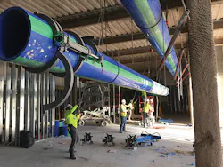 An overhead run of large-diameter Aquatherm pipe being hoisted into place. Note the prototype McElroy Acrobat™ 630 fusion machine’s jaws on the pipe. An overhead run of large-diameter Aquatherm pipe being hoisted into place. Note the prototype McElroy Acrobat™ 630 fusion machine’s jaws on the pipe.