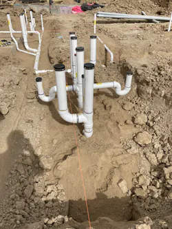 Centennial High School Construction Site | Fall 2021: Prefabricated, PVC pipe configuration for a school restroom with a toilet, two floor drains and connections for sinks on the opposite side. Creating multiple, complex pipe configurations like this under the highly controlled conditions of a prefab shop is a huge improvement over building them from scratch in the field. Centennial High School Construction Site | Fall 2021: Prefabricated, PVC pipe configuration for a school restroom with a toilet, two floor drains and connections for sinks on the opposite side. Creating multiple, complex pipe configurations like this under the highly controlled conditions of a prefab shop is a huge improvement over building them from scratch in the field.