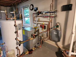 The new mechanical room. Left to right are a 42-gal. Viessmann Vito DHW tank, a Viessmann Vito Rond cast iron boiler, a Grundfos circulator and (on the wall) a Zilmet Model ZFT expansion tank. Above, on the wall, is a Viega Model 12152 Enhanced Mixing Station (with another Grundfos circulator on the left-hand side). The new mechanical room. Left to right are a 42-gal. Viessmann Vito DHW tank, a Viessmann Vito Rond cast iron boiler, a Grundfos circulator and (on the wall) a Zilmet Model ZFT expansion tank. Above, on the wall, is a Viega Model 12152 Enhanced Mixing Station (with another Grundfos circulator on the left-hand side).