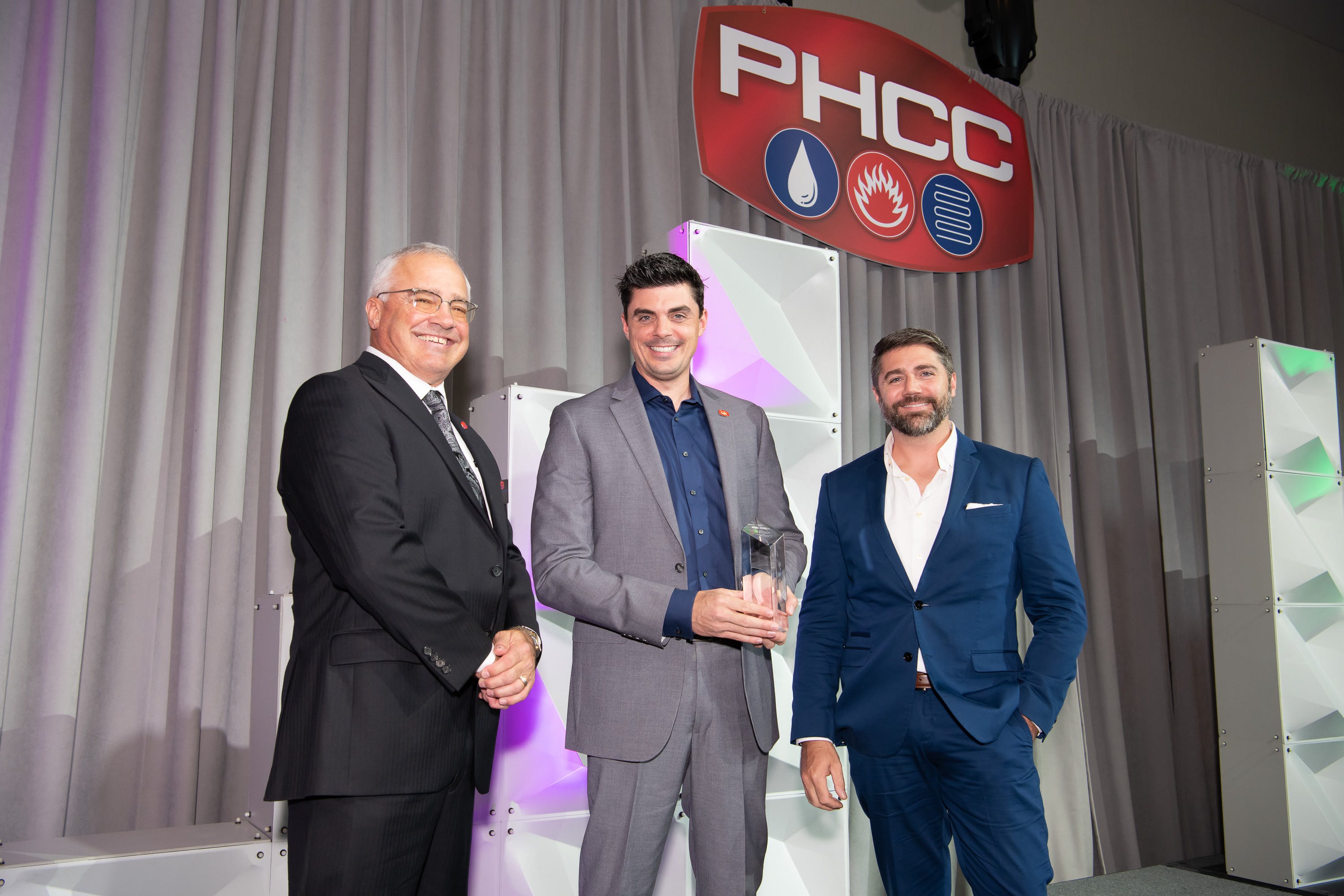 From left to right, presenter Dave Frame (2022-2023 PHCC-National President), Tony Bertolino (holding the award) and Rob Bertolino.