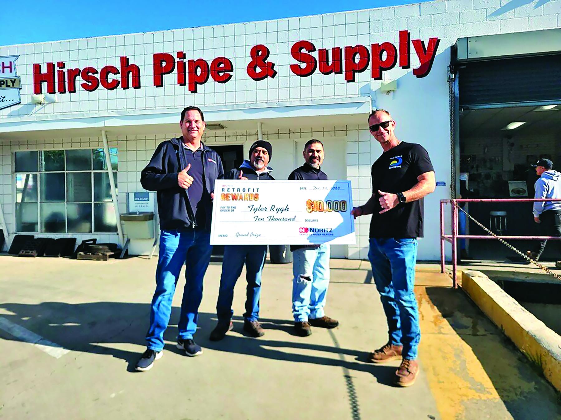 Tyler Rygh (far right) of All Coast Plumbing & Rooter accepts $10,000 grand prize in Noritz&rsquo;s Retrofit Rewards promotion from Noritz SoCal Territory manager Dylan Stieler (far left).