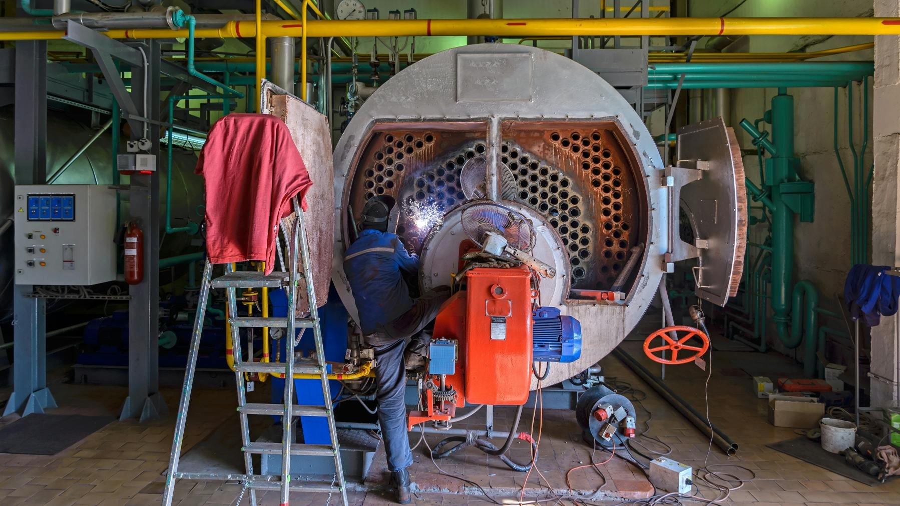 A worker repairing a boiler.