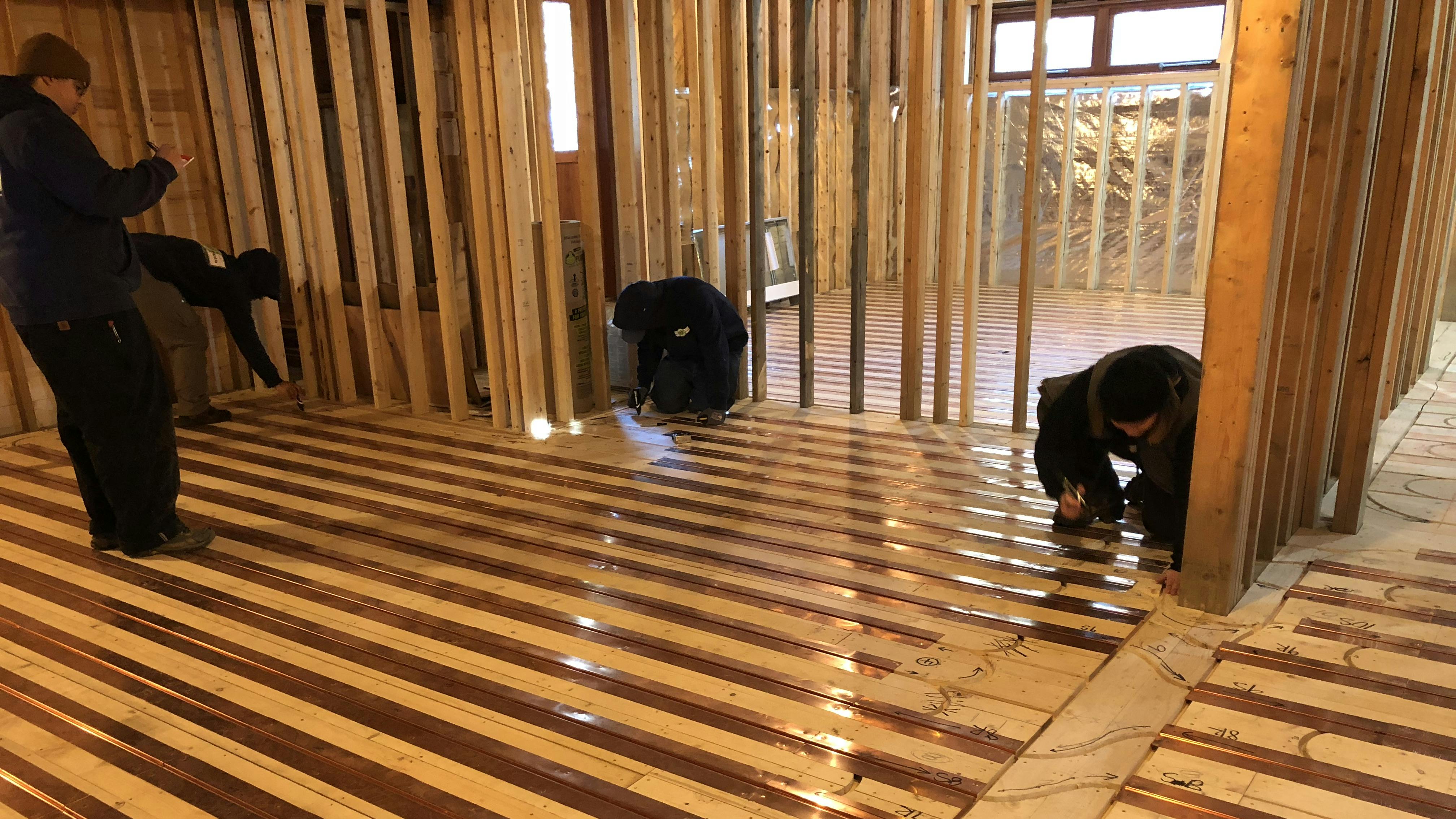 Nailing down copper radiant panels.