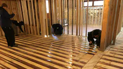 Nailing down copper radiant panels. Nailing down copper radiant panels.