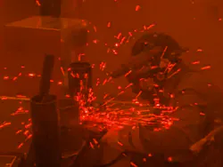 A competitor in one of the welding competitions behind a protective fire screen. A competitor in one of the welding competitions behind a protective fire screen.