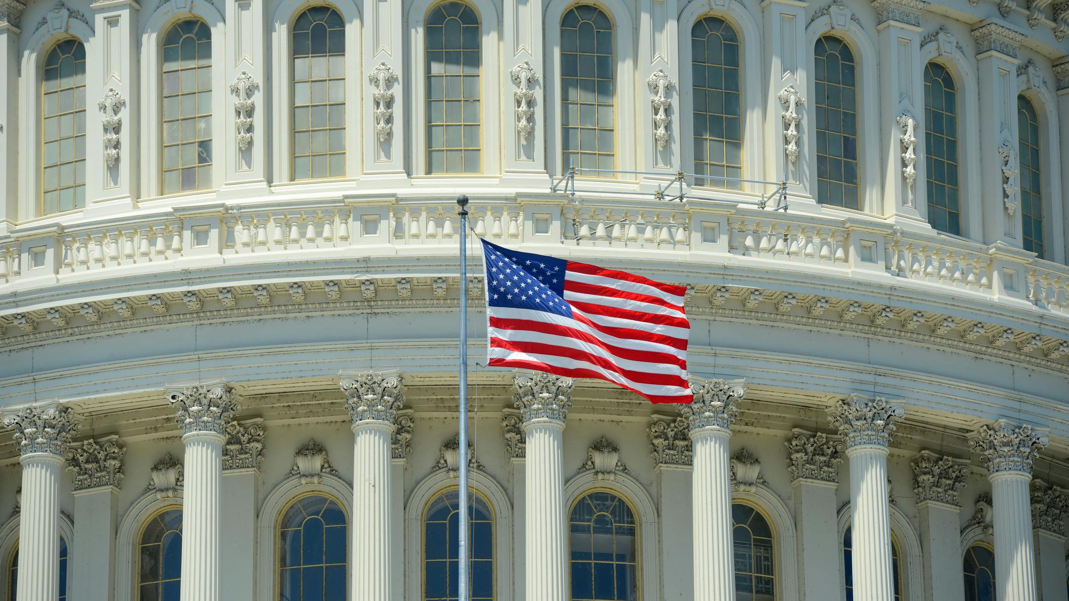 National Flag in front of United State Capitol Building in Washington, District of Columbia, USA.