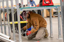 A competitor in the apprentice competition lines up a pipe hanger. A competitor in the apprentice competition lines up a pipe hanger.