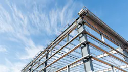 Steel frame workshop is under construction against a blue sky Steel frame workshop is under construction against a blue sky