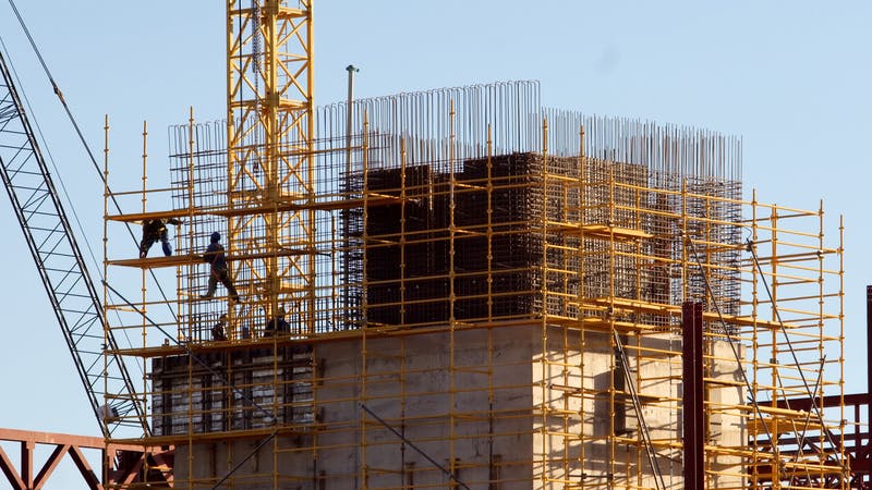 Construction workers climbed on scaffolding.