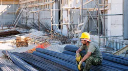 Construction worker resting on steel bars. Construction worker resting on steel bars.