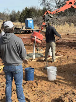 Pouring concrete as part of the well installation. Pouring concrete as part of the well installation.