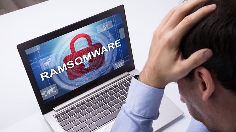 Worried Businessman Looking At Laptop With Ramsomware