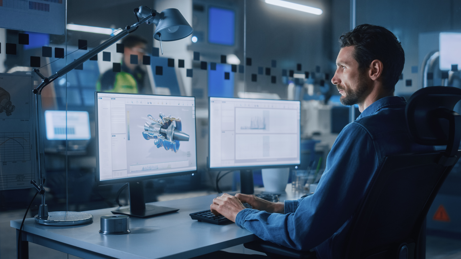 Industrial Engineer Solving Problems, Working on a Personal Computer, Two Monitor Screens Show CAD Software
