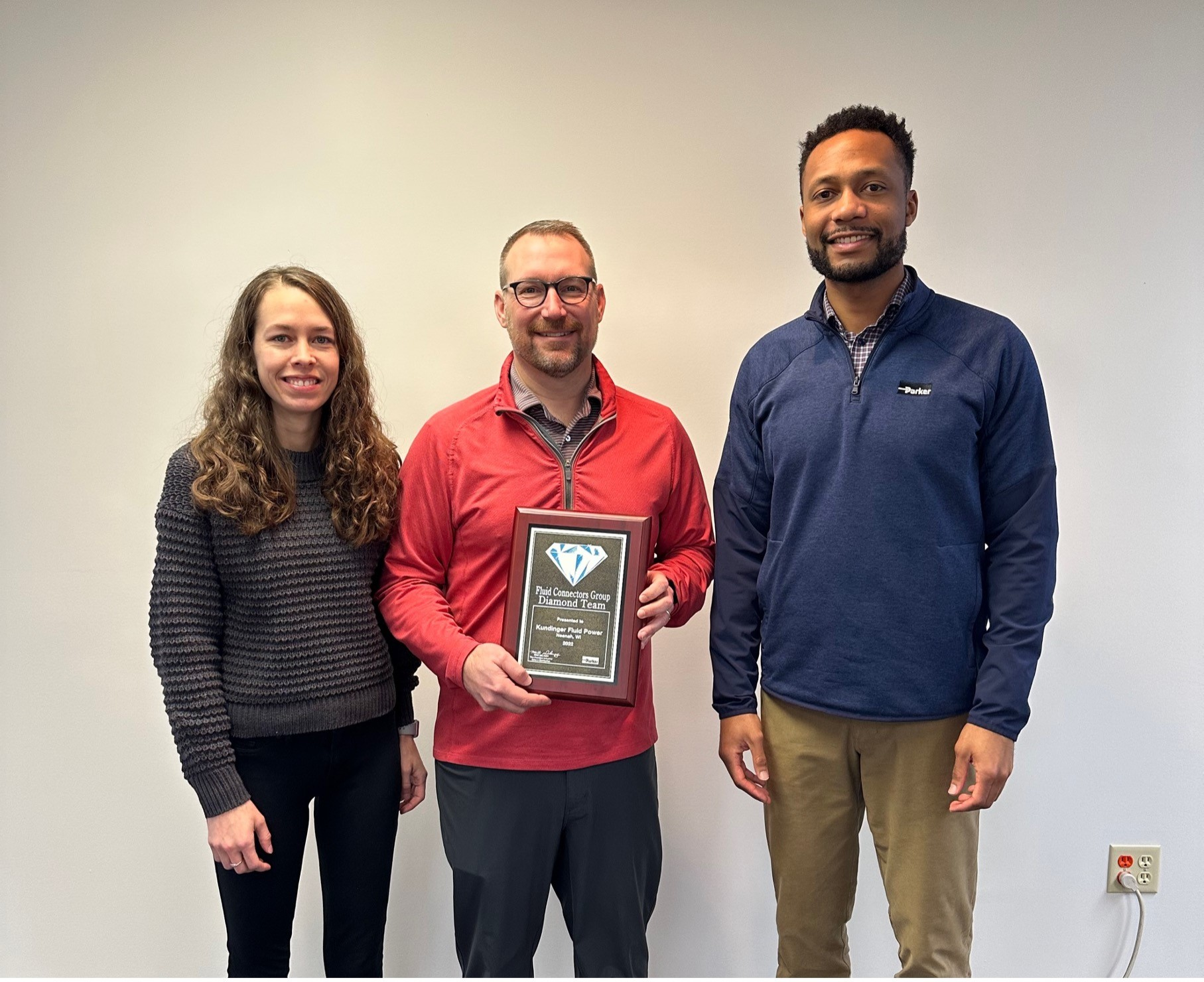 Paul Kundinger (from left), president of Kundinger, receiving the Diamond Team Award from Ashley Nagel, connector territory manager, and Matt Davis, regional manager, for Parker Hannifin.