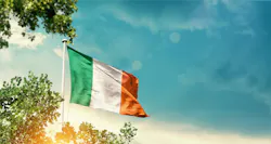 Ireland national flag waving in the sky behind the tree Ireland national flag waving in the sky behind the tree