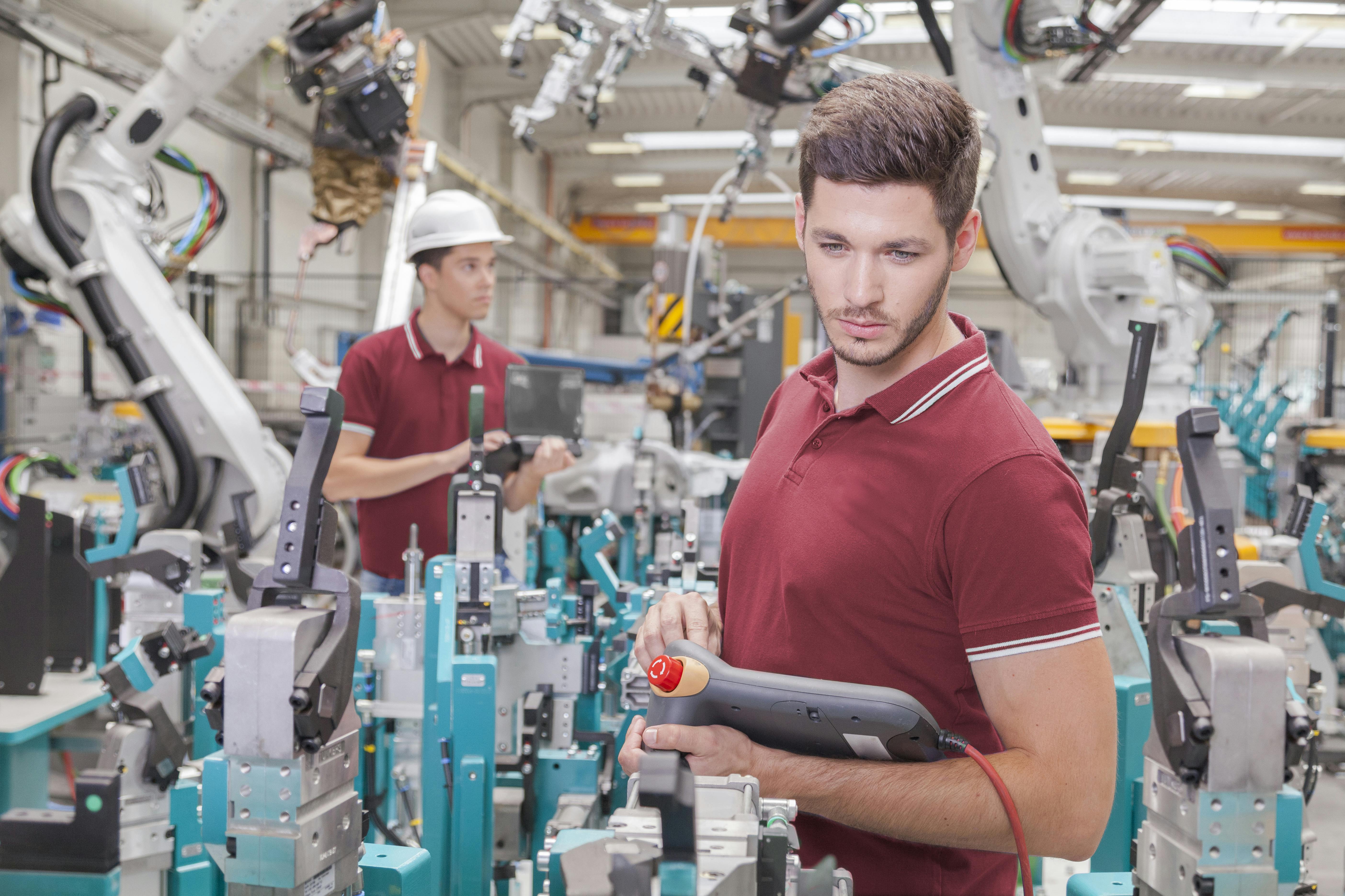 two engineers check functionality while commissioning a production line in welding shop