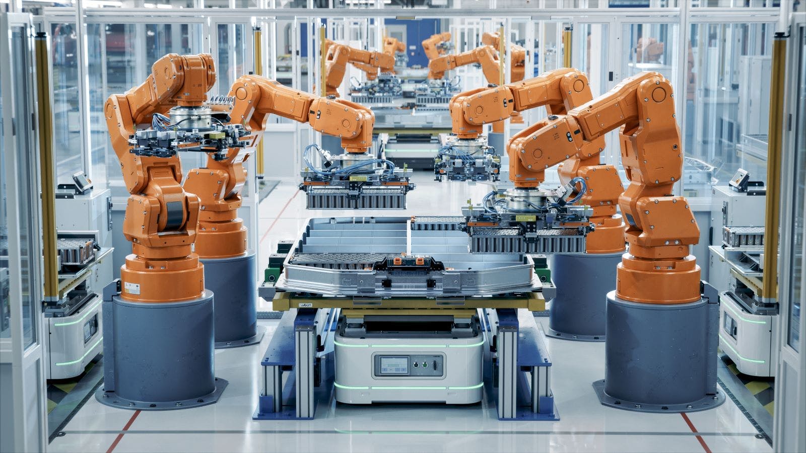 Row of Robot Arms inside Bright Plant Assemble Batteries for Automotive Industry.