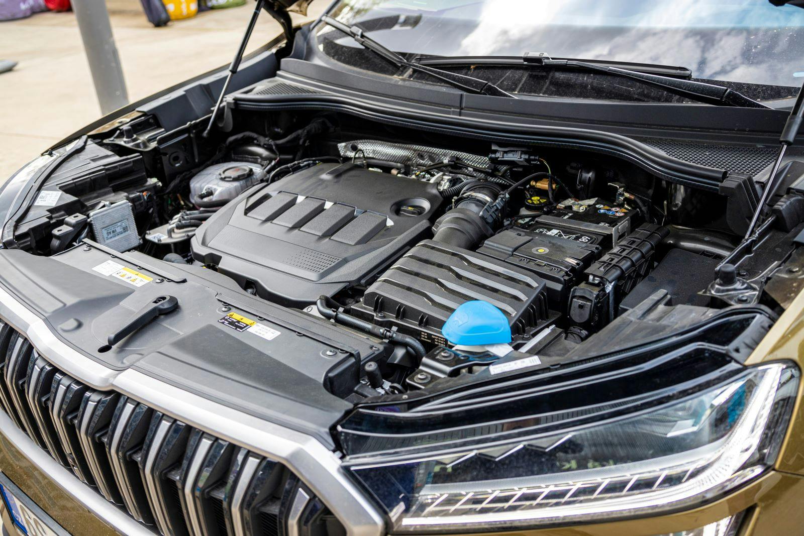 A view of the engine compartment of a modern brown combustion SUV with a large spacious body