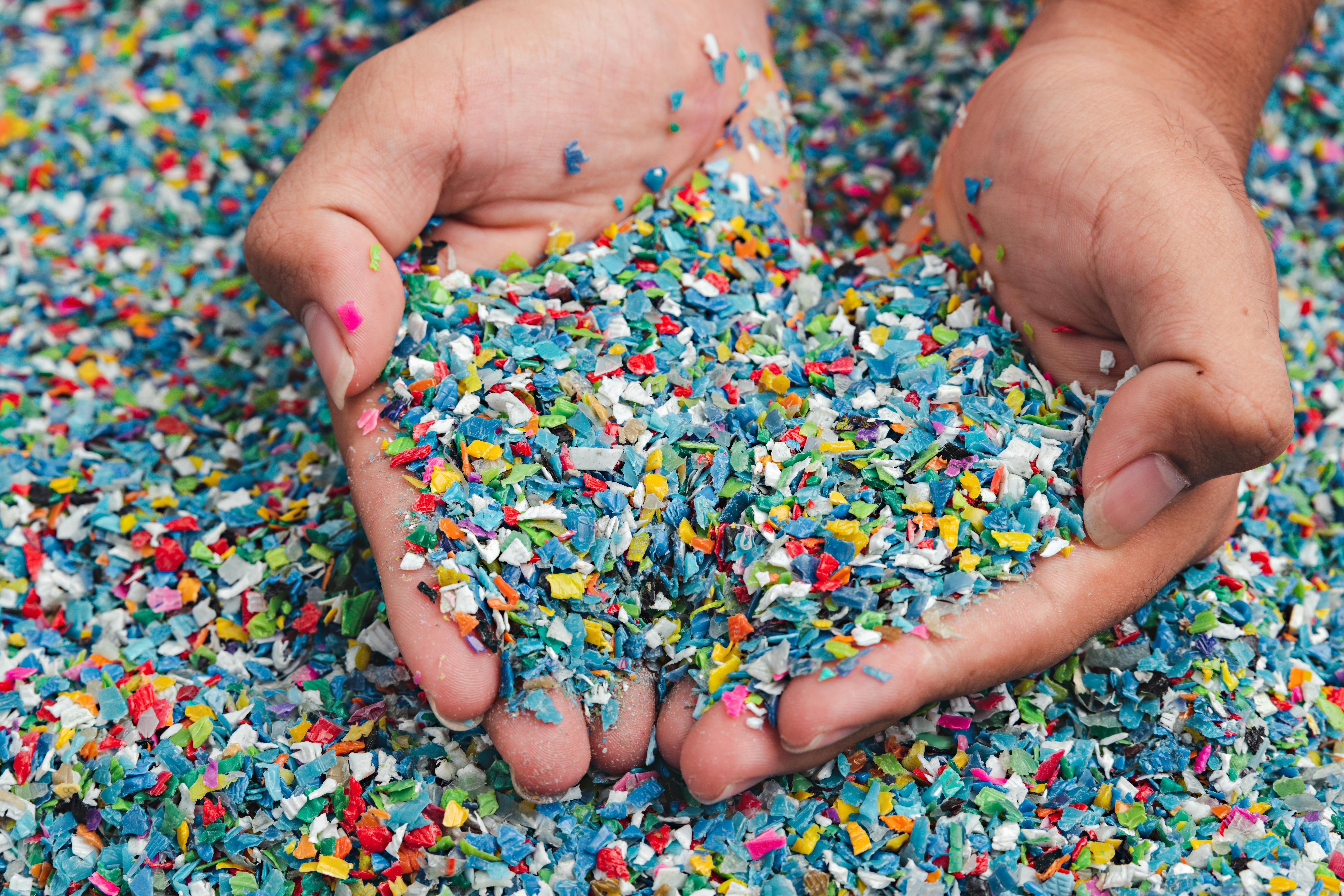 Cupped handfuls of multi-colored plastic pieces