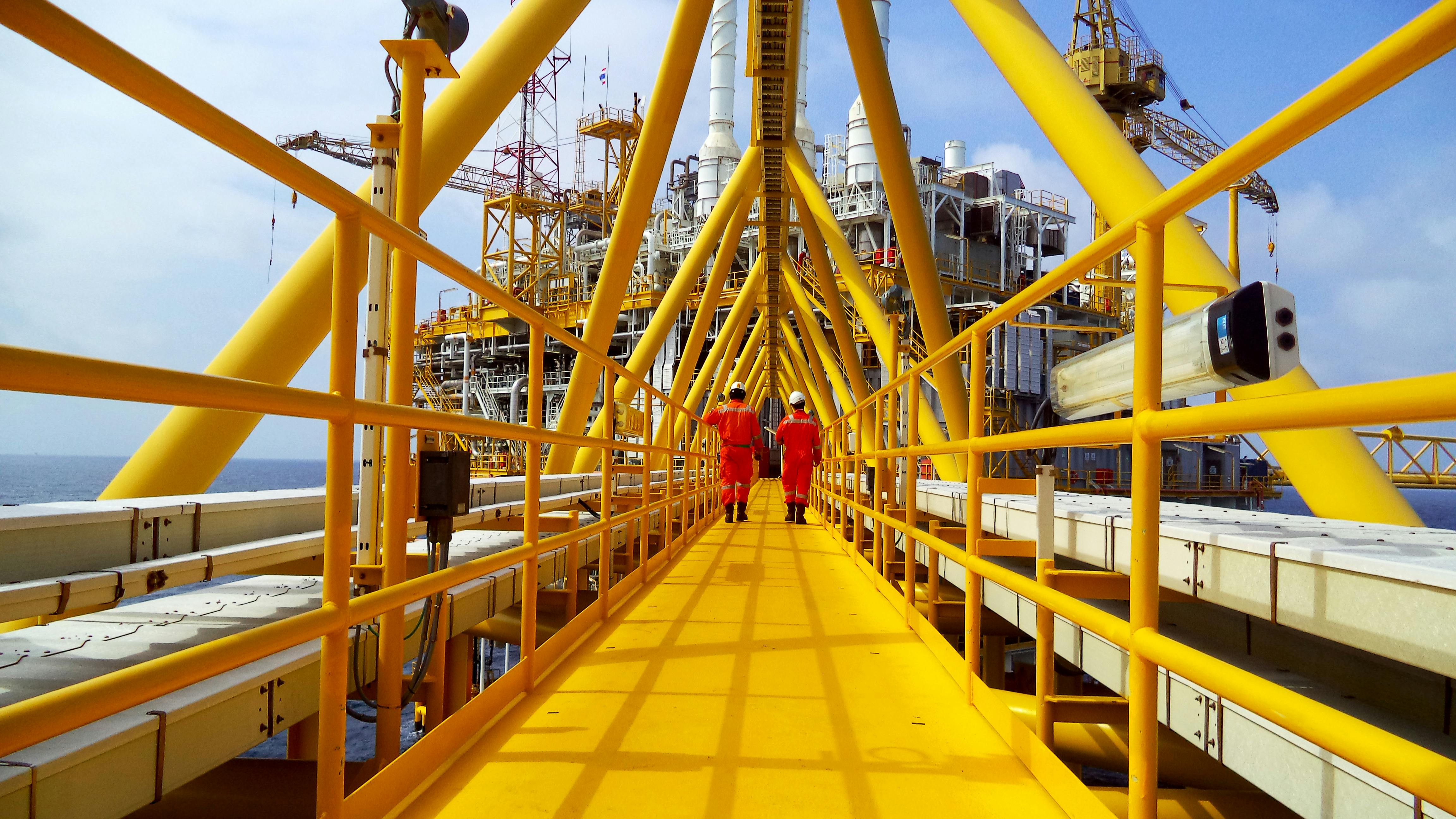 Operator walking operation of oil and gas process at oil and rig plant.