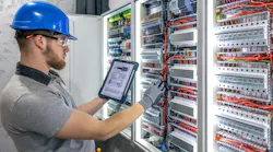 Electrician analyzing circuit. Tablet in hand. Technical preparation. Electrician analyzing circuit. Tablet in hand. Technical preparation.