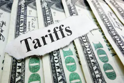 The word 'Tariffs' typed on a scrap of paper laid atop several $100 bills The word 'Tariffs' typed on a scrap of paper laid atop several $100 bills