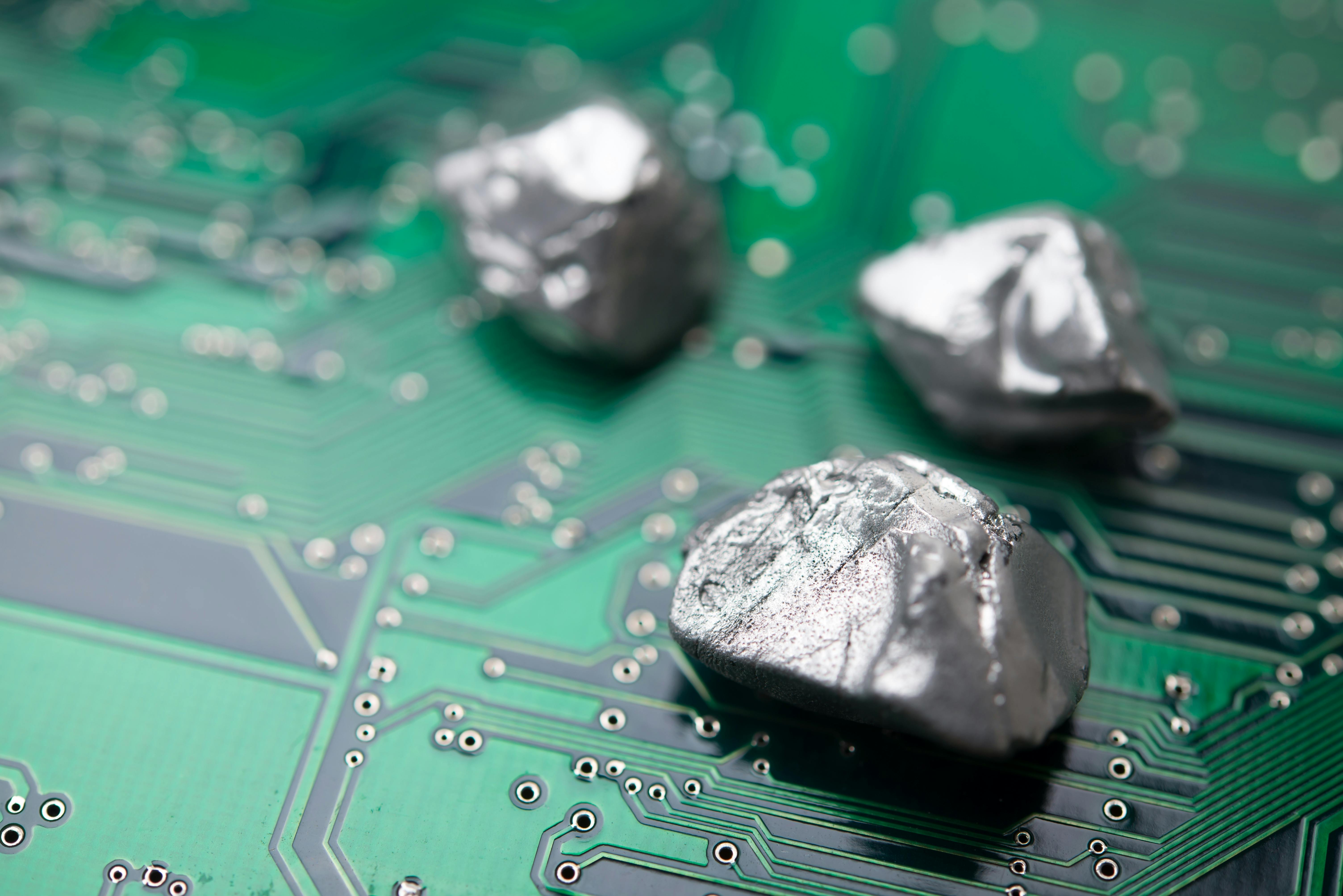 Mineral rare earth element on green electronic circuit board background.