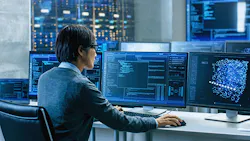 man at work station in control room reviewing multiple displays with analytics data and modeling man at work station in control room reviewing multiple displays with analytics data and modeling